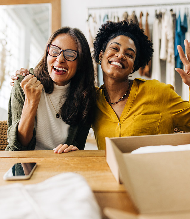 Two business women celebrating a sale