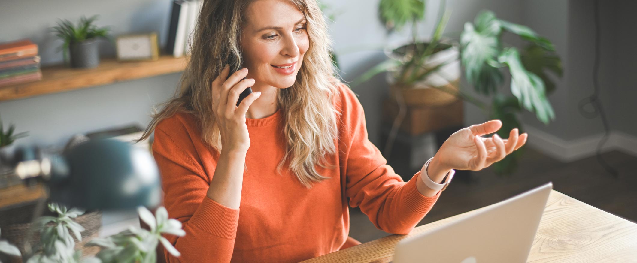 Woman talking on phone while on computer