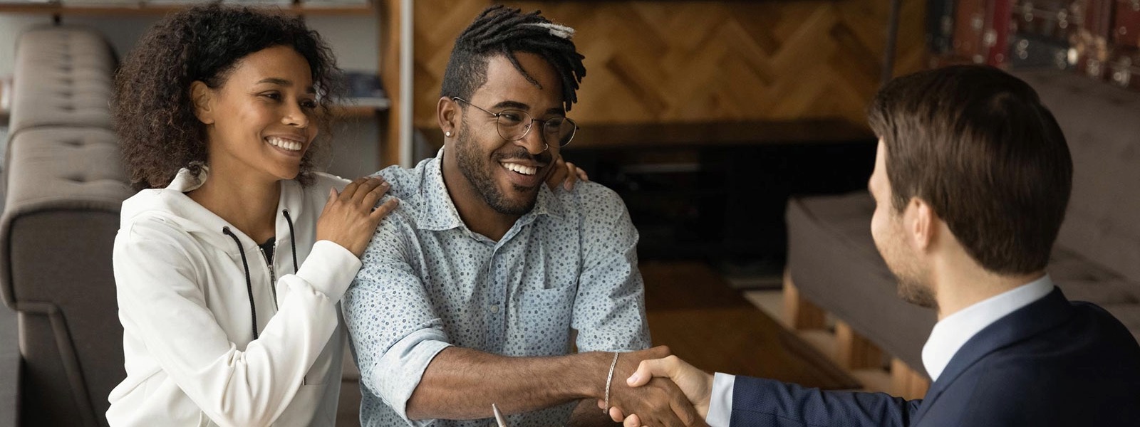 Young couple shaking hands with a loan officer