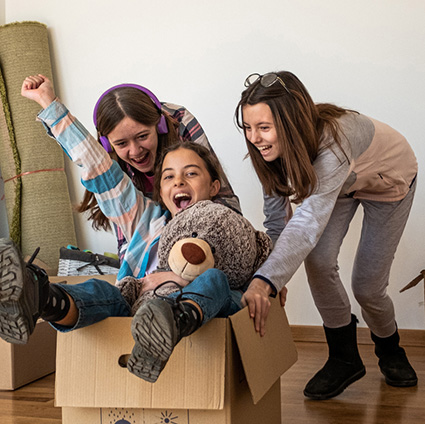 Three kids playing with moving boxes