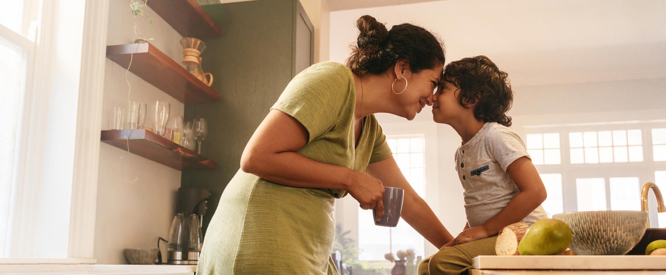 Mother and child snuggling in kitchen